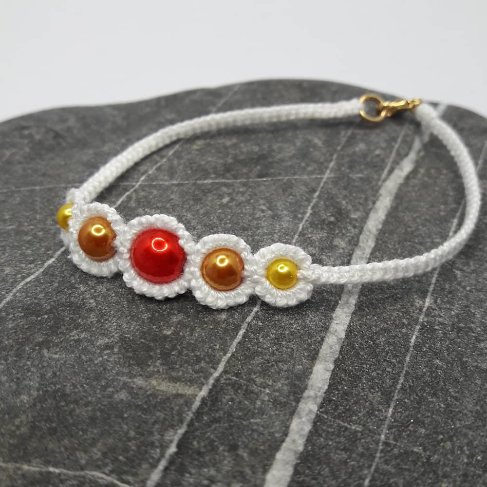 zierliches Armband Nicolina aus weißer Baumwolle mit Perlen in Sonnentönen: gelb, orange und rot