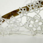 Detailansicht filigrane auffällige Kette aus weißer Baumwolle mit vielen kristallfarbenen Perlen