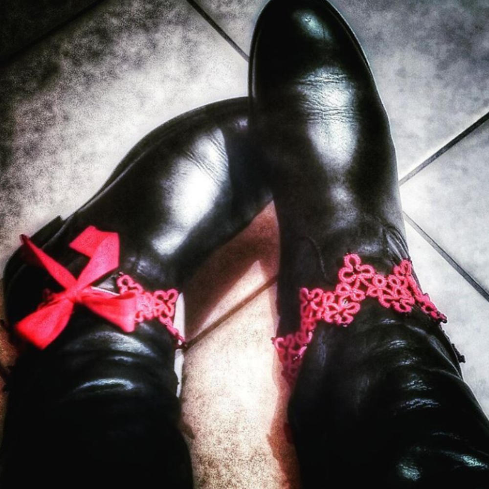 Schuhspitze Milano aus roter Baumwolle mit schwarzen Perlchen zieren ein Paar schwarzer Stiefel