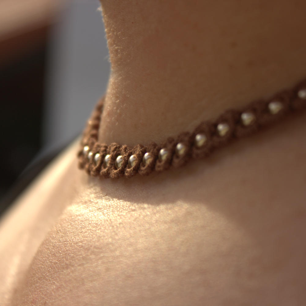 Detailansicht Kette Simple ELeganz aus brauner Buamwolle mit goldfarbenen Perlen